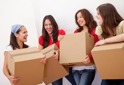 Professional movers carrying furniture through a Bayswater property